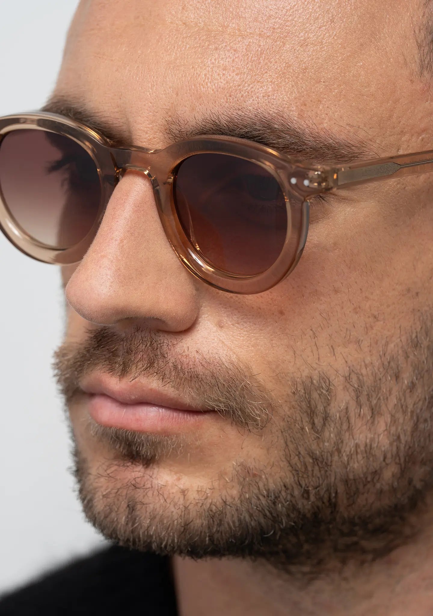 mens sunglasses Bo Bo Noir William round in crystal peach acetate with CR-39 gradient brown lenses, man wearing, side view.