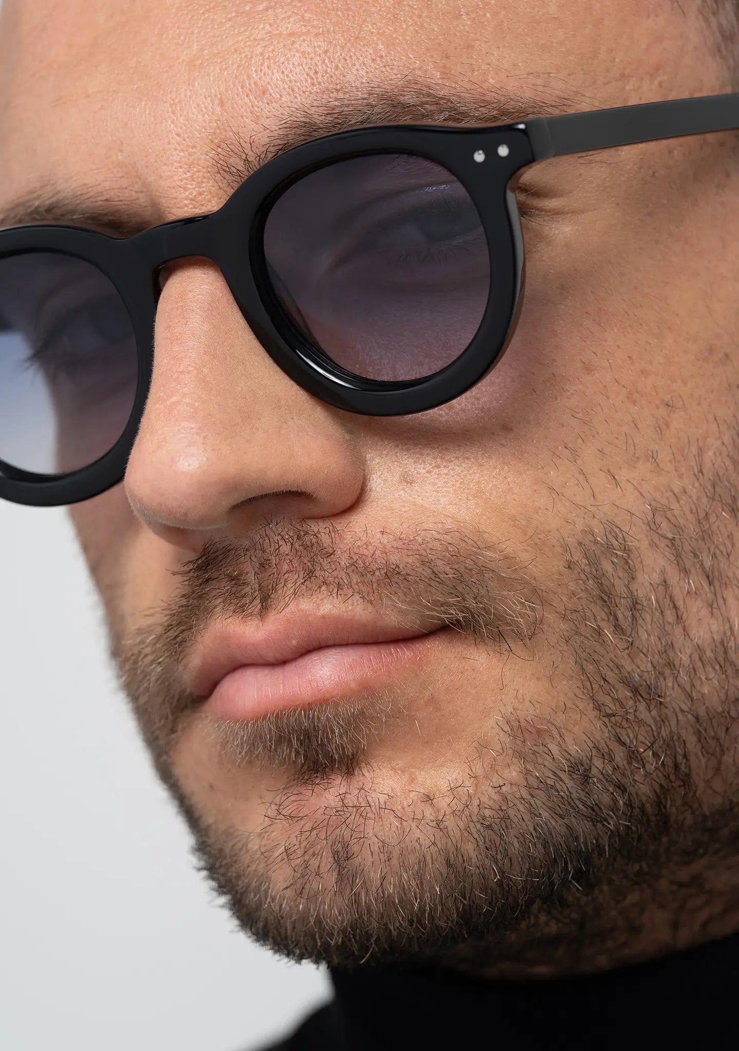 mens sunglasses Bo Bo Noir William round in shiny black acetate with CR-39 gradient blue lenses, man wearing, side view.