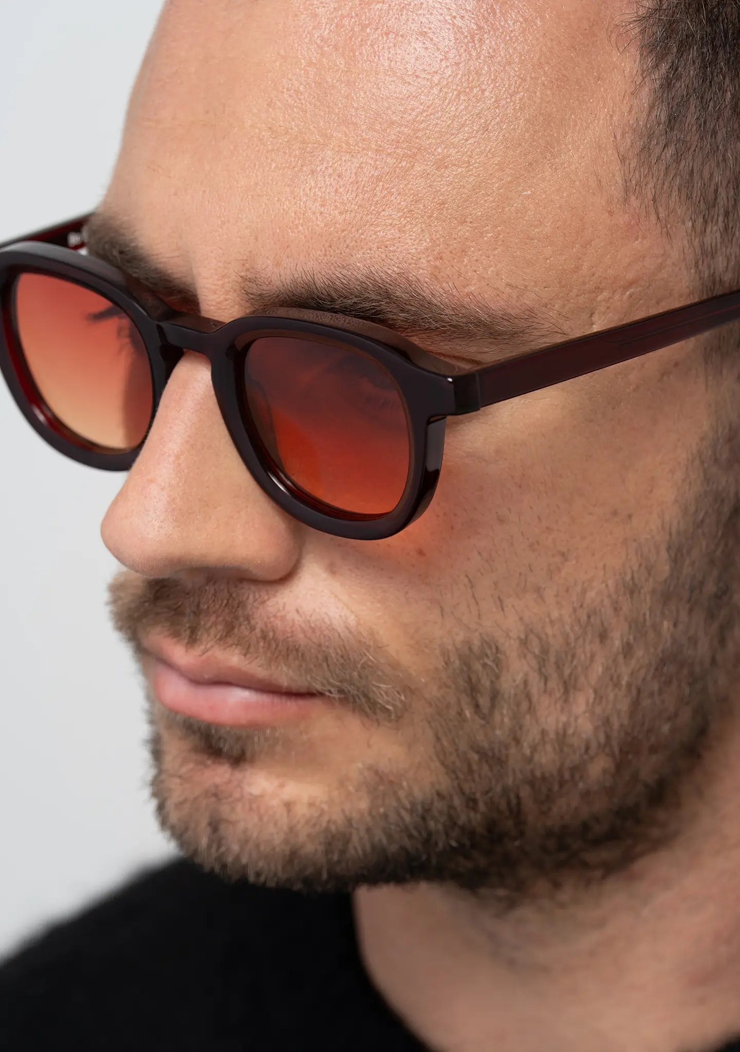 mens sunglasses Bo Bo Noir Narr panto round in deep burgundy acetate with gradient sunset red nylon lenses, man wearing, side view.