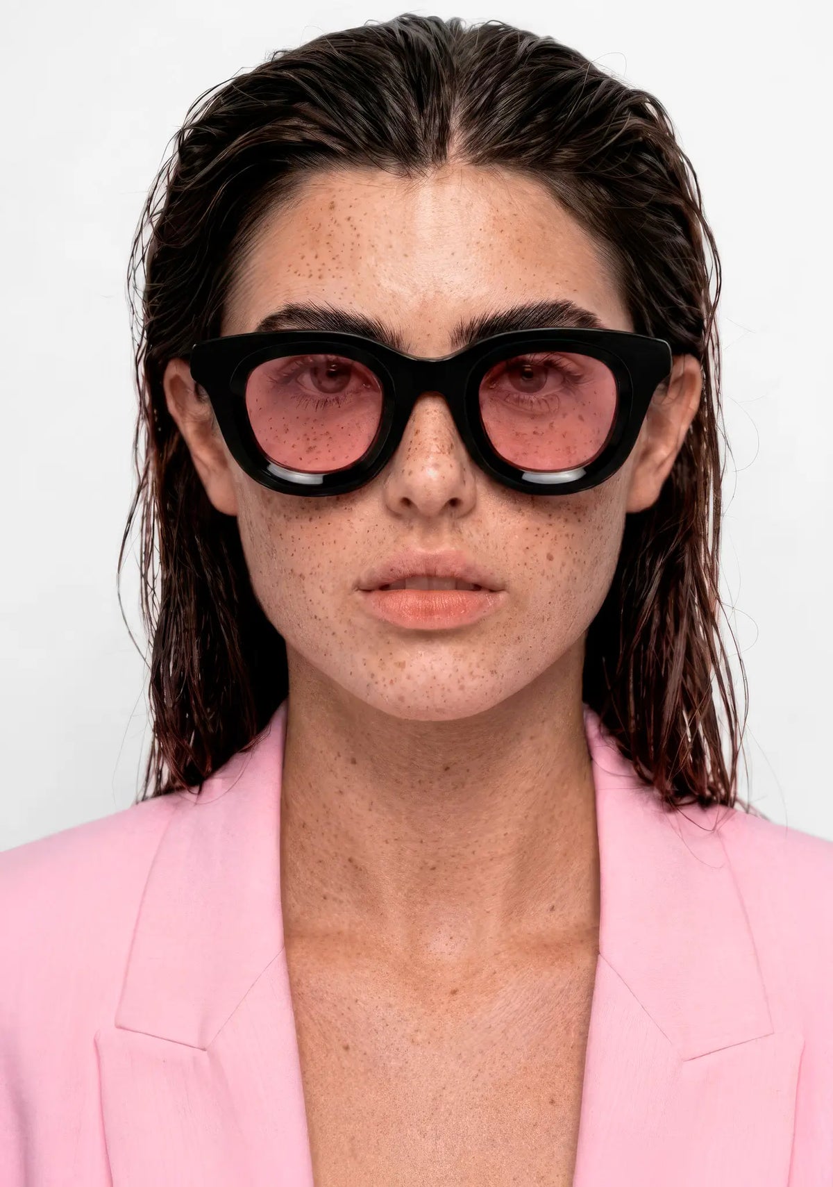 womens Triboulet panto sunglasses with shiny black acetate frame and pink lenses, front view on model