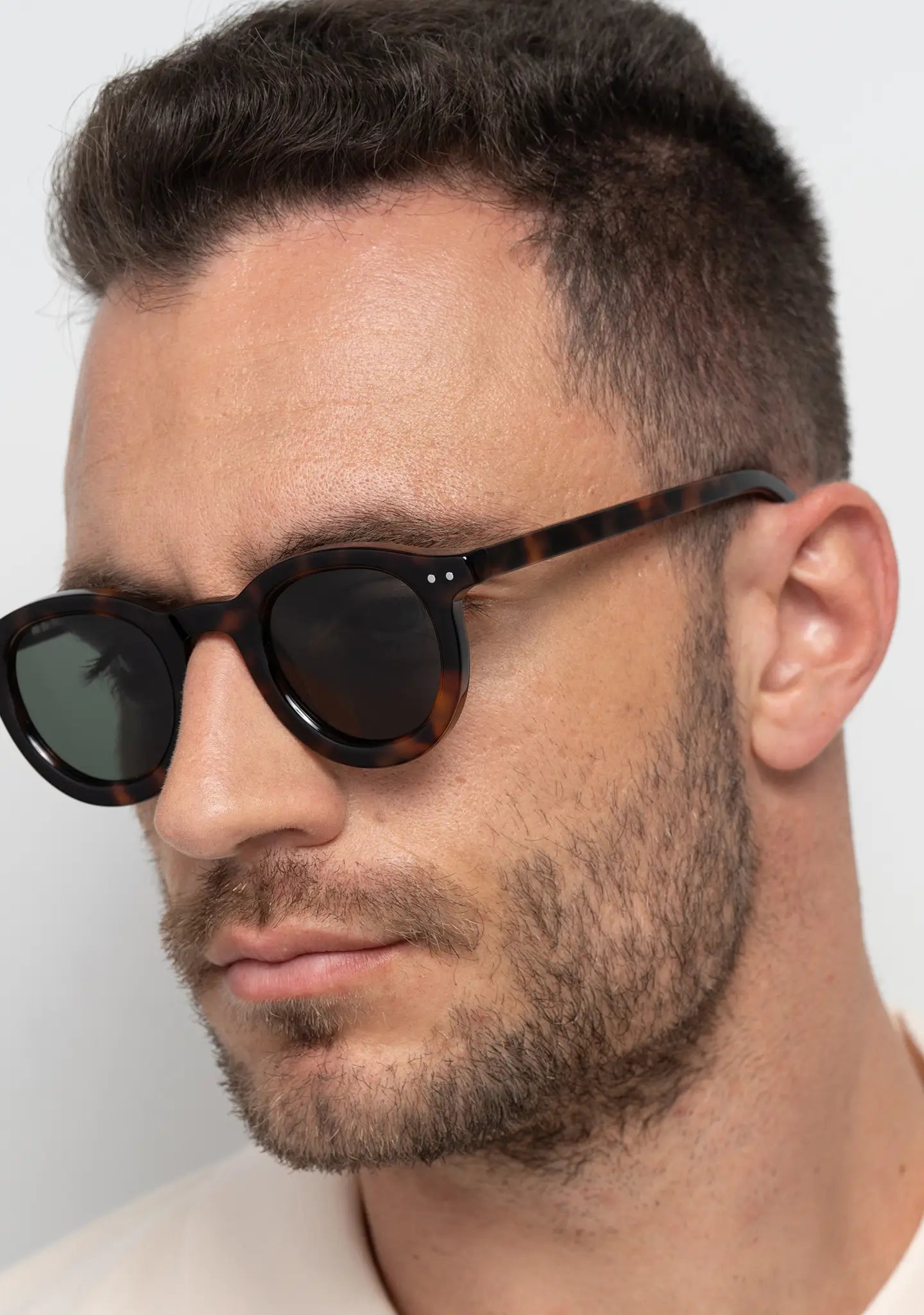 mens sunglasses Bo Bo Noir William round in tortoise acetate with single green lenses, man wearing, side view.