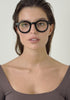 Womens wearing William Bold Classic Round Blue Light Blocking Glasses in Shiny Black acetate frame with blue light blocking lenses. Captures sleek minimalism with advanced eye protection. 